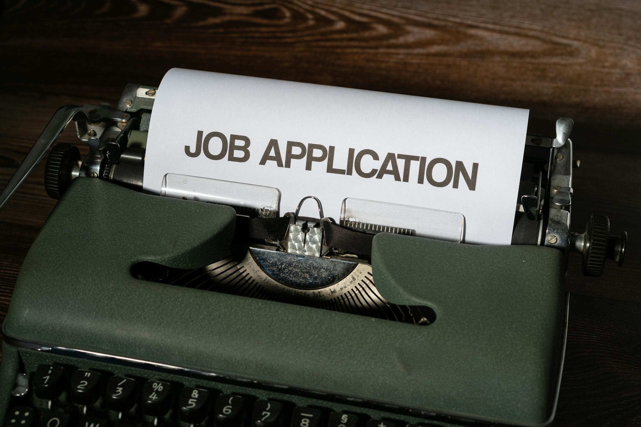 Close-up of a vintage typewriter with a job application paper inserted.